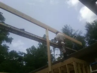 Carpenter setting a ridge beam over a new addition frame — Ice Dam Removal by Roofing Brothers in Eatonville